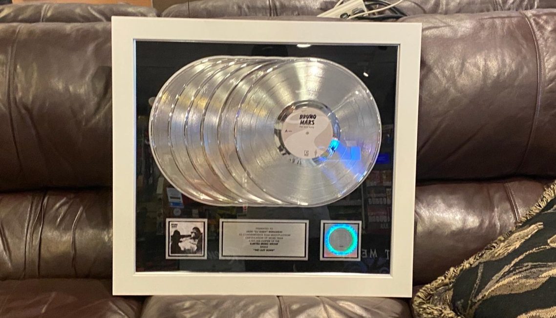 RIAA Platinum Award Framed display featuring multiple platinum record awards and a plaque.