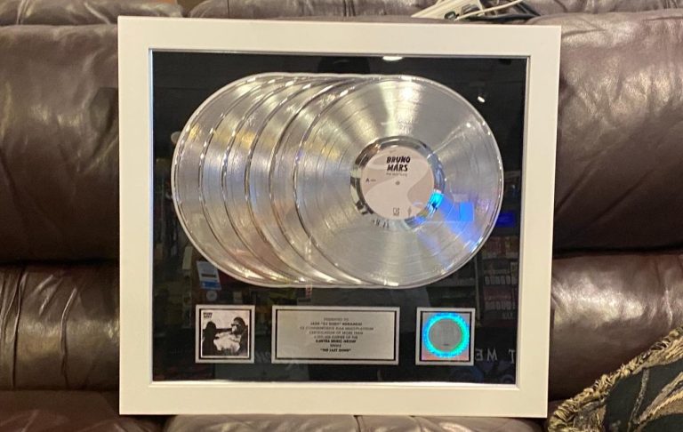 RIAA Platinum Award Framed display featuring multiple platinum record awards and a plaque.
